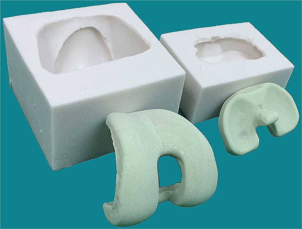 Fig. 1 
            Antibiotic-impregnated articulating cement spacers and silicone molds.
          